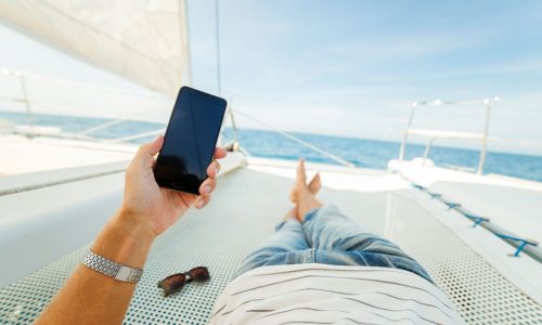 man-looks-at-phone-on-boat.jpg